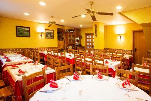 - un restaurant avec des tables et des chaises avec des serviettes rouges dans l'établissement Hostal Musunzar, à Leitza