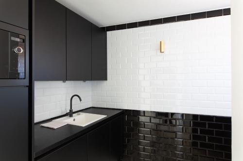 - une cuisine avec des placards noirs et un évier dans l'établissement Rooftop View - 2 BdR 2 BthR 1 toil - Clim Terrace Elevator small Parking, à Cannes