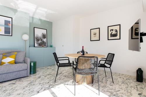 un salon avec une table, des chaises et un canapé dans l'établissement Rooftop View - 2 BdR 2 BthR 1 toil - Clim Terrace Elevator small Parking, à Cannes