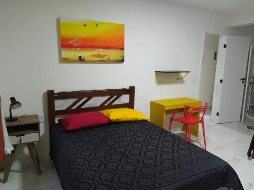 a bedroom with a bed and a painting on the wall at Lindo Apartamento na Praia do Futuro in Fortaleza