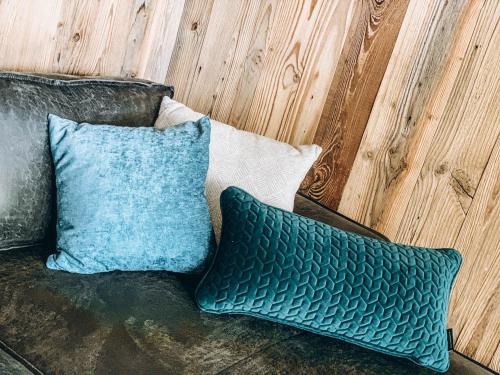a couch with two blue pillows on it at FOUR PEAKS Apartment in Flachau