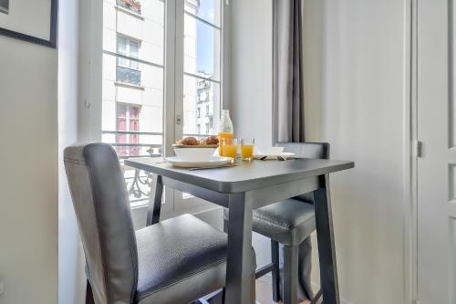 - une table avec un bol de nourriture et 2 chaises dans l'établissement Cute Mezzanine Studio in the Heart of Paris (2M), à Paris