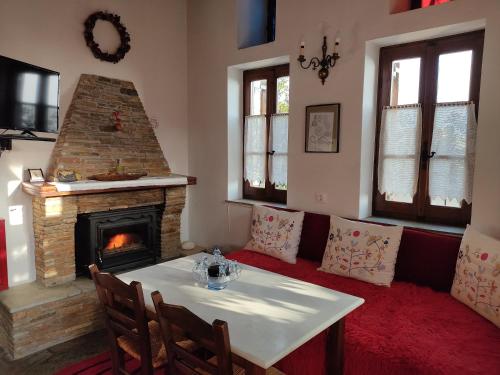 a living room with a table and a fireplace at Archontiko Repana - Makrinitsa Stone Retreat in Makrinítsa