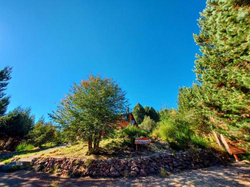 uma colina com árvores e um sinal no meio em Las Retamas em Villa Pehuenia