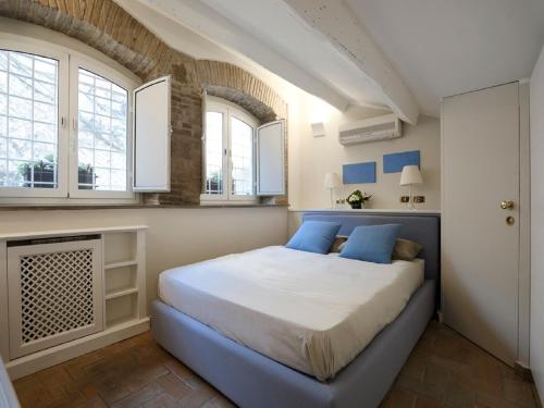 1 dormitorio con 1 cama con almohadas y ventanas azules en Antiche Residenze Romane - CAMPO DE' FIORI, en Roma