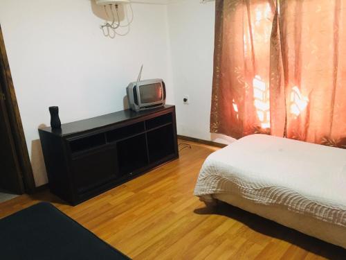 a bedroom with a bed and a tv on a dresser at alquiler apto. para Brasileros cerca del estadio Centenario, para Conmebol in Montevideo
