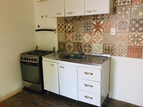 a small kitchen with a sink and a stove at alquiler apto. para Brasileros cerca del estadio Centenario, para Conmebol in Montevideo