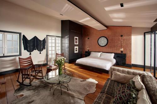 a bedroom with a bed and a living room with a couch at La Valise Mexico City in Mexico City