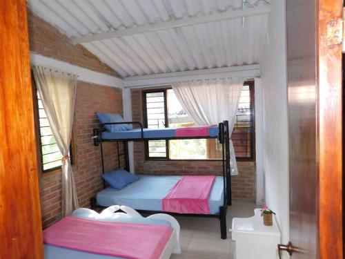 1 Schlafzimmer mit 2 Etagenbetten in einer Ziegelwand in der Unterkunft Sauna y Jacuzzi en medio de la naturaleza in Cachipay