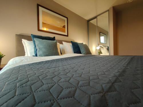 una camera da letto con un grande letto con cuscini blu di Luxury City Centre 2 bedroom apartment a Sheffield
