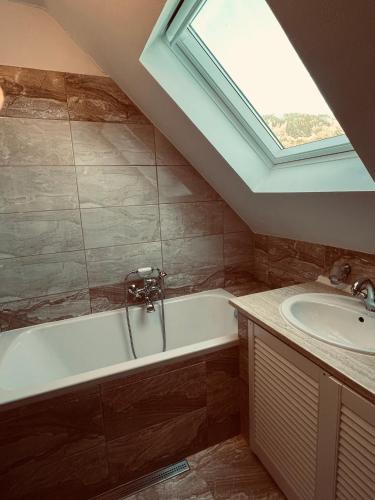a bathroom with a bath tub and a sink at Chalupa Jáchymov - ubytování v srdci Krušných hor in Jáchymov
