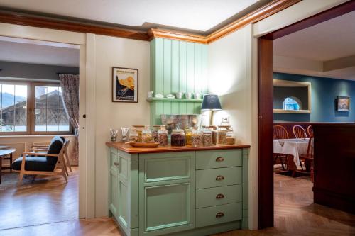 a room with a green cabinet with food on it at Boutique Hotel Bellevue Lermoos in Lermoos
