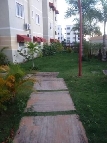 a walkway in a yard next to a building at Apartment in Ciudad Juan Bosch. in Los Paredones