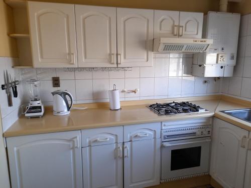 a kitchen with white cabinets and a stove top oven at Departamento Temuco Thiers in Temuco