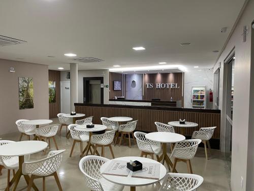 Un restaurante con mesas y sillas y un bar. en TS HOTEL, en Porteirinha