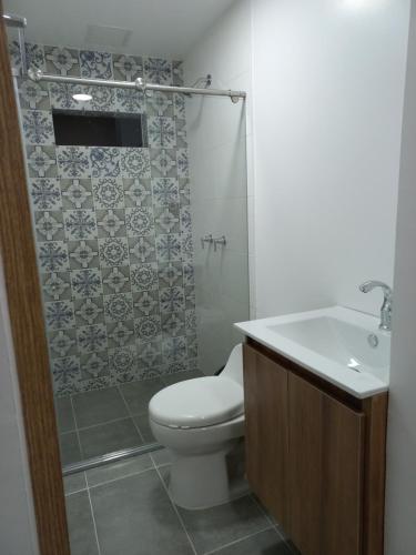 a bathroom with a toilet and a shower and a sink at Apartamento vacacional FL Martinz in Manizales
