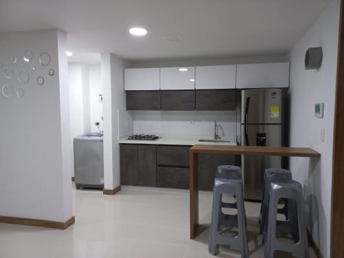 a kitchen with a counter and two bar stools at Apartamento vacacional FL Martinz in Manizales