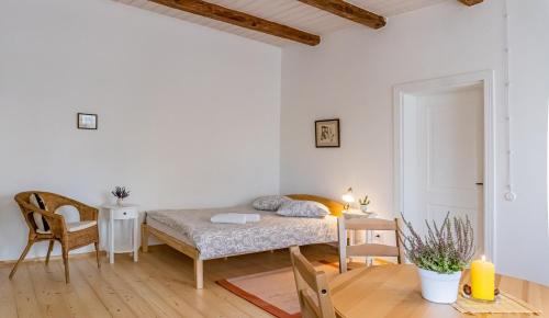 a small bedroom with a bed and a table at Pālena apartamenti in Tērvete