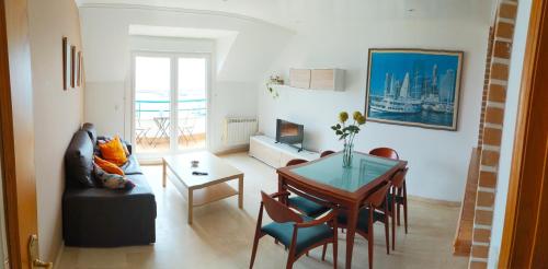 salon ze stołem i jadalnią w obiekcie Precioso ático con vistas a pie de playa w mieście Sanxenxo