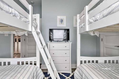 a bedroom with two bunk beds and a tv at Newly Built DAUPHIN ISLAND Home! in Dauphin Island