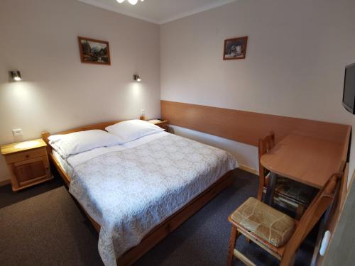 a bedroom with a bed and a table and a desk at Willa Hamernik AGROTURYSTYKA in Tylicz