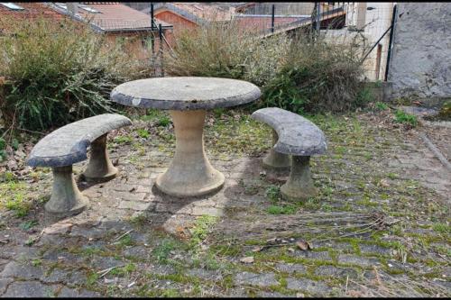 une table en pierre et trois bancs de champignons dans une cour dans l'établissement En pleine montagne T1 30m2 parking à coté, à Amplaing