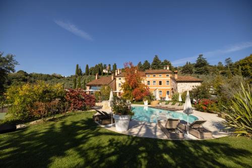 特耶內的住宿－Borghetto San Biagio Relais Agriturismo，房屋前带游泳池的大院子