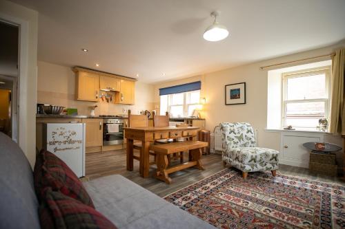a living room with a table and a kitchen at The Starry Rock in Kirriemuir