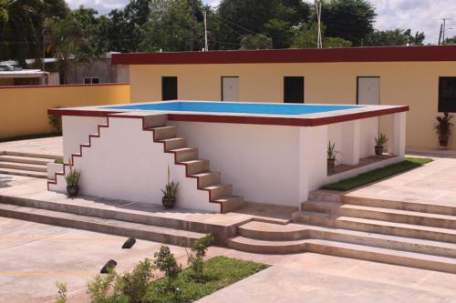 a building with a staircase in front of it at Hotel La Piramide Izamal in Izamal