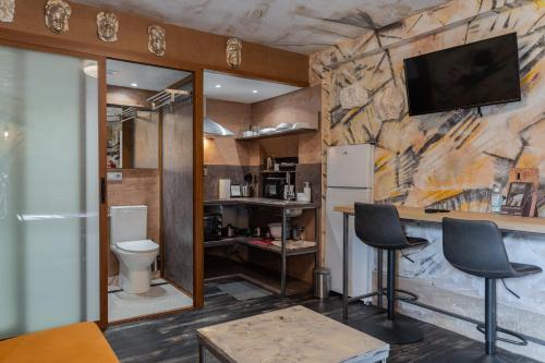 a room with a bar with a sink and a refrigerator at Domus Lapidis - La Galeria in Bogarra