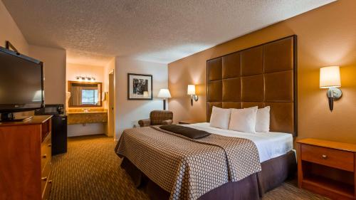 a hotel room with a bed and a flat screen tv at Best Western Inn Of Pinetop in Pinetop-Lakeside