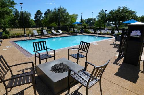 a pool with chairs and a table in front of it at Garner Hotel Longview South by IHG in Longview