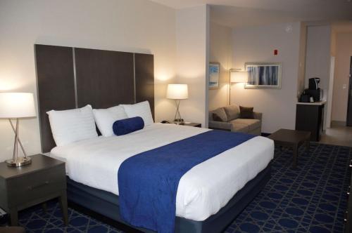 a hotel room with a large bed and a couch at Garner Hotel Longview South by IHG in Longview