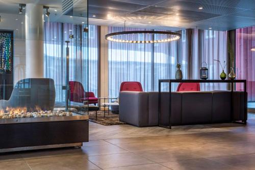 a lobby with a fireplace and red chairs at Radisson Blu Hotel Tromsø in Tromsø