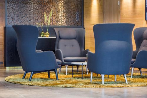 - une salle d'attente avec des chaises bleues et une table dans l'établissement Radisson Blu Hotel Tromsø, à Tromsø