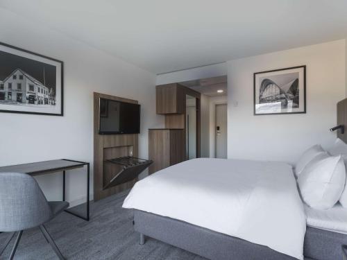 a bedroom with a bed and a desk and a tv at Radisson Blu Hotel Tromsø in Tromsø