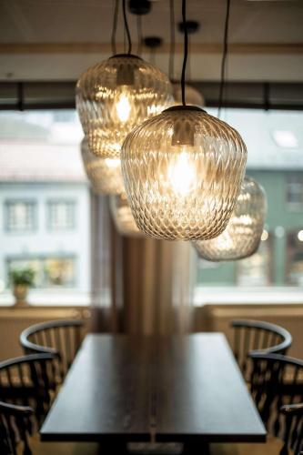a table with chairs and lights hanging over it at Radisson Blu Hotel Tromsø in Tromsø