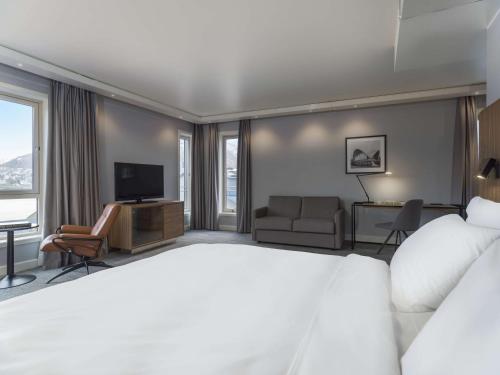 a hotel room with a large bed and a television at Radisson Blu Hotel Tromsø in Tromsø