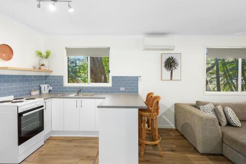 a kitchen and living room with a couch at Flynns Beach Caravan Park in Port Macquarie