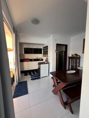 a living room with a table and a kitchen at Casa Marambaia in Rio de Janeiro