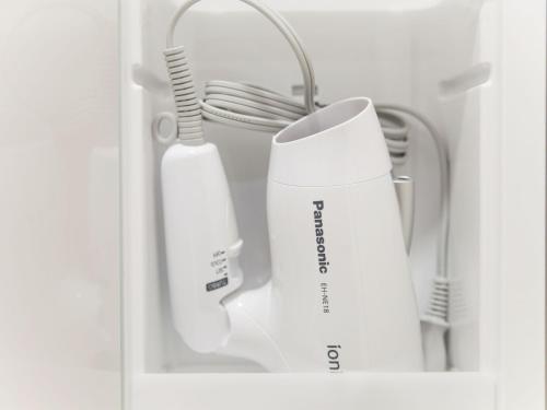 a shelf with two toothbrushes and a white appliance at Kevin's Place in Kyoto