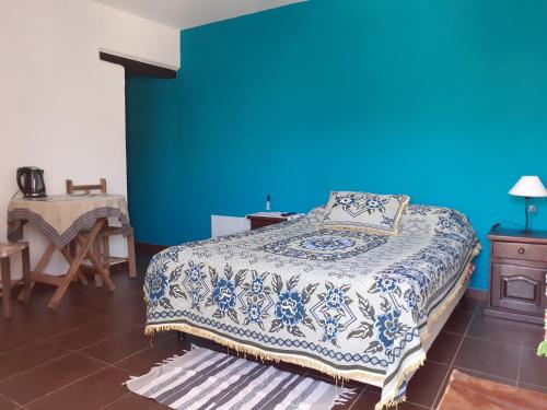 a bedroom with a bed with a blue wall at " La Casa de Joaquin" in Tilcara