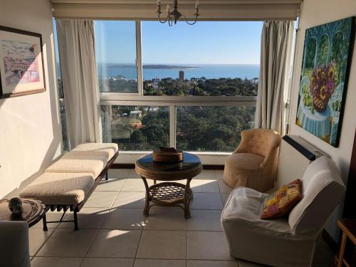 sala de estar con sofás y ventana grande en Piso alto con gran vista al mar y la isla, Torre Ibiza, en Punta del Este