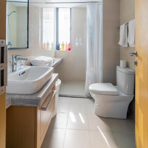 uma casa de banho branca com um lavatório e um WC em Guanlan Pavilion Seaview Homestay em Wenchang