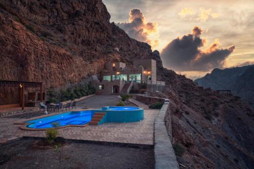 a house in a mountain with a swimming pool at Tilal Al-Qattara in Mashūq