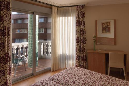 a bedroom with a bed and a window with a balcony at Pontus Veteris in Sanxenxo