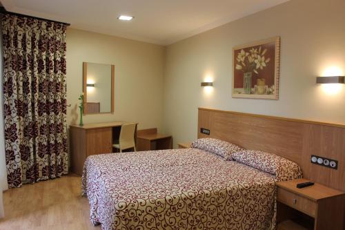 a hotel room with a bed and a desk at Pontus Veteris in Sanxenxo