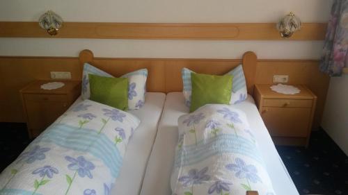1 Schlafzimmer mit 2 Betten mit grünen und blauen Kissen in der Unterkunft Apart Garni La Fontana in Kappl
