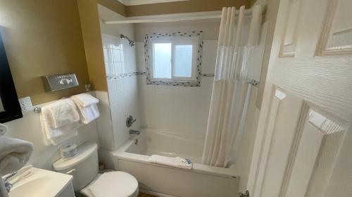 ein Badezimmer mit einem weißen WC und einer Dusche in der Unterkunft Travellers Motel in Cranbrook