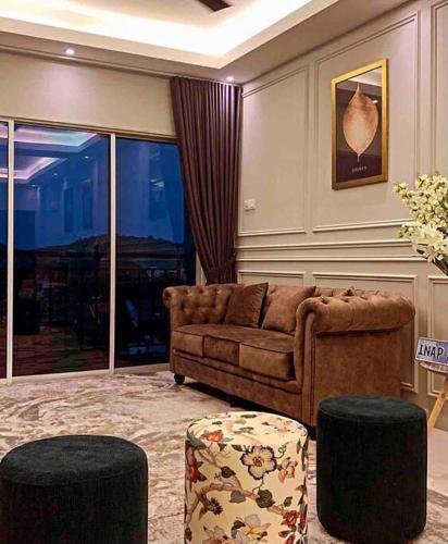a living room with a couch and two stools at Inap Kayangan @ Puncak Alam with Swimming Pool in Bandar Puncak Alam